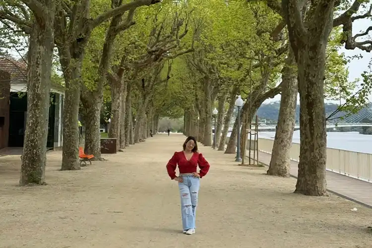 A brasileira Elisa Delgado, em meio a árvores na cidade de Coimbra.