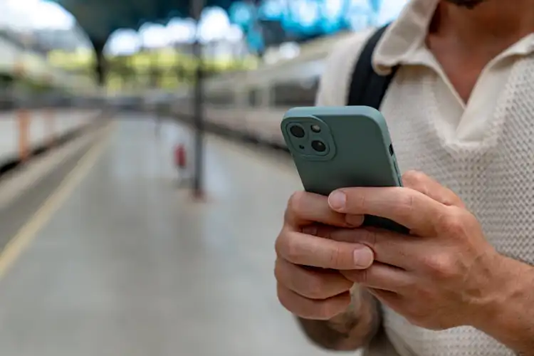 Homem usando celular na rua