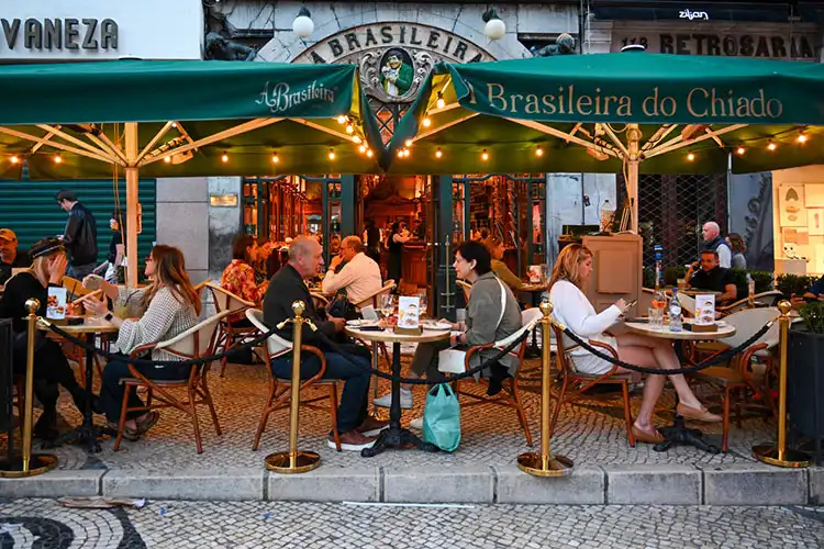 Esplanada do Café A Brasileira na Rua Garrett em Lisboa ao entardecer, Portugal.