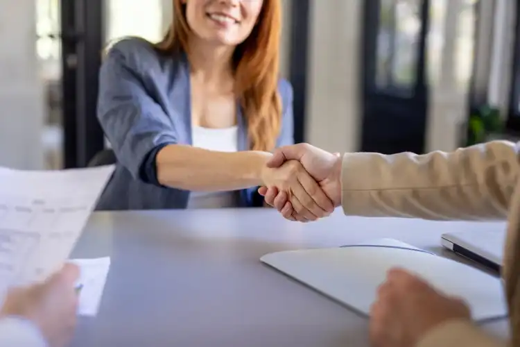Recrutadora apertando a mão de candidata.