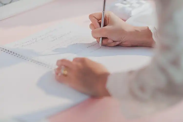 Mulher assina documentos para tirar cidadania alemã por casamento