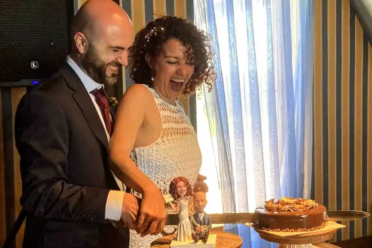 Casal corta bolo em festa de casamento
