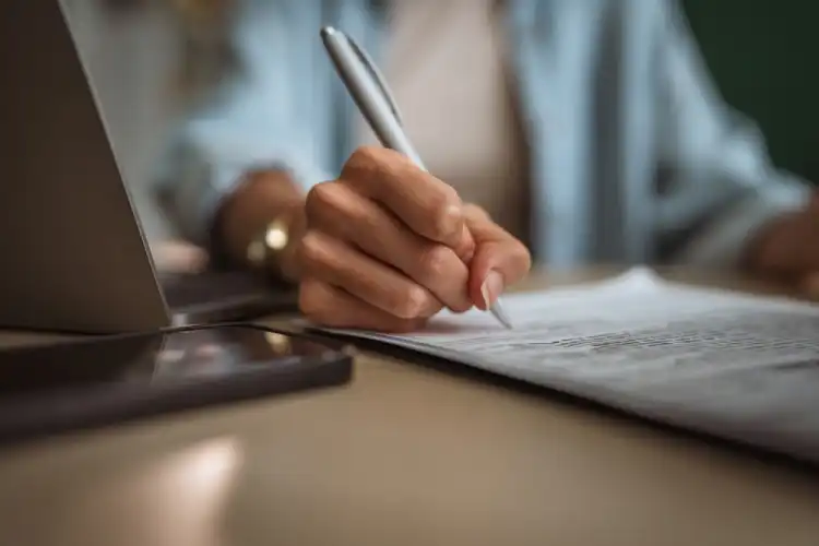 Pessoa assinando a tradução de documentos importantes