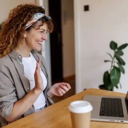 Mulher feliz em chamada de vídeo aprendendo idiomas online depois de escolher entre Italki ou Preply