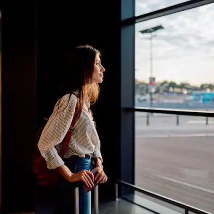 Mulher jovem esperando pelo seu voo no aeroporto