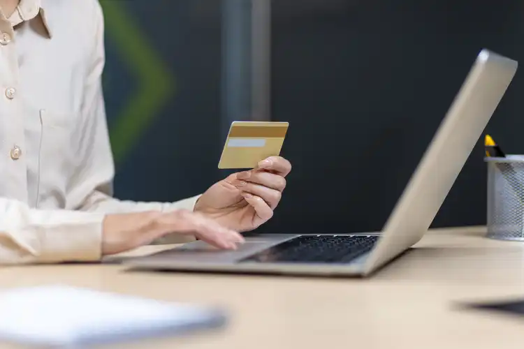 Pessoa faz compras online com cartão de crédito.