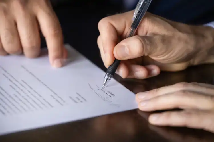 Pessoa assinando documento