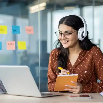 Mulher com fones de ouvido faz curso de italiano online em laptop.