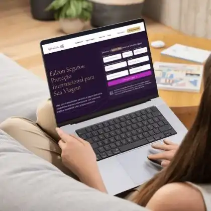 Pessoa usando um notebook no sofá enquanto acessa o site da Falcon Seguros