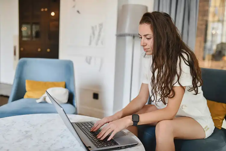Mulher fazendo pesquisa no notebook de quartos para alugar em Lisboa