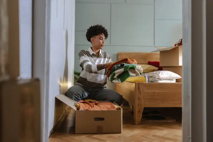 Jovem organizando seu quarto.