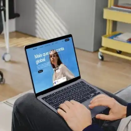 Pessoa usando um notebook para acessar o site da Revolut Brasil em uma sala de estar.