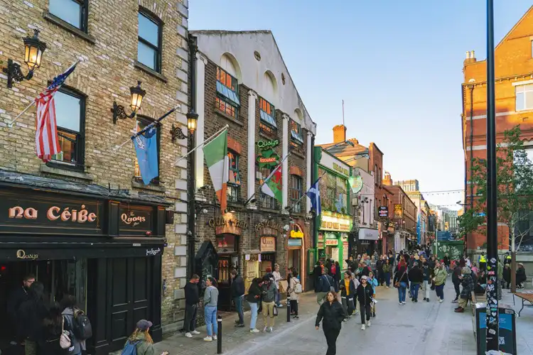 Locais e turistas aproveitando dia de sol na região do Temple Bar em Dublin.