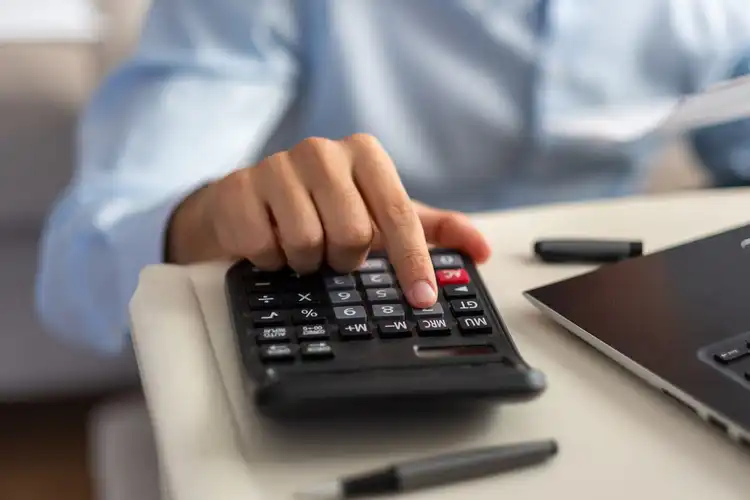 Pessoa calcula taxa de IOF para gastos de viagem internacional.