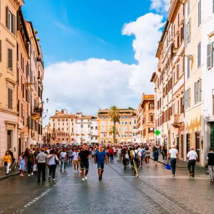Rua movimentada em Roma entre prédios históricos, ilustrando o cotidiano urbano na Itália, onde o custo de vida é alto nas grandes cidades.