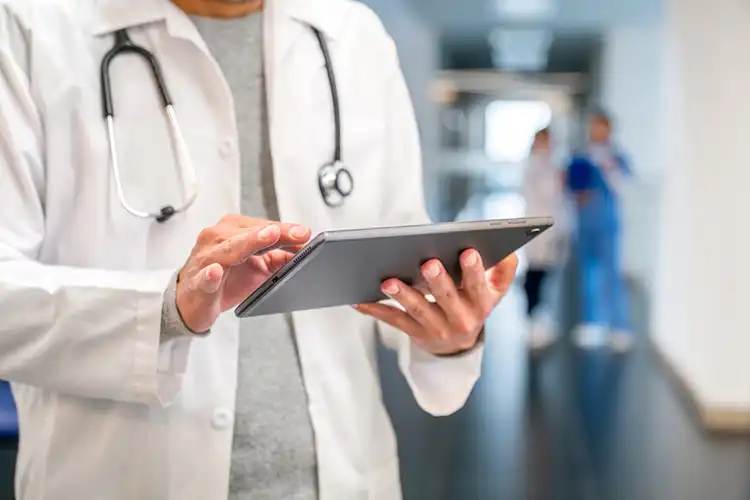Médico de família acompanhando as informações do paciente em um tablet
