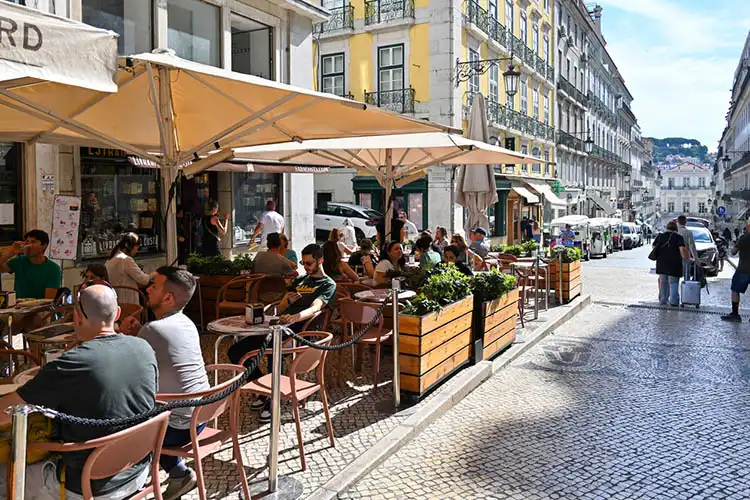 Varanda de um café com mesas na calçada em Lisboa