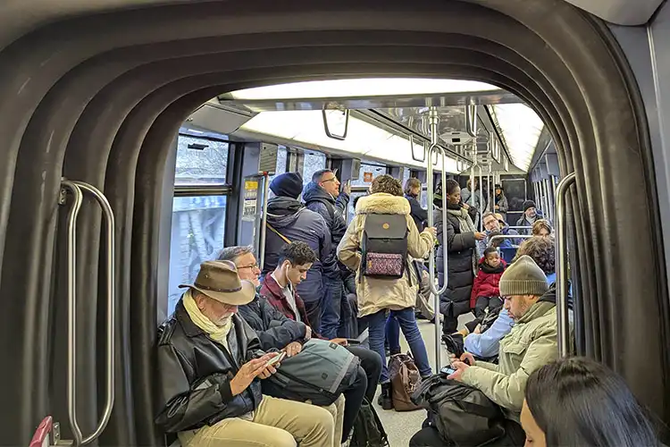 Pessoas em vagão de metrô utilizando smartphone com chip de celular na França