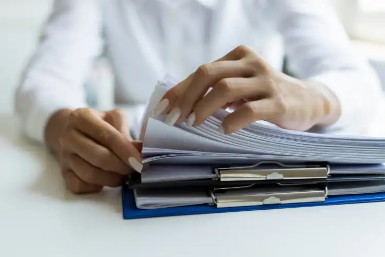 Profissional organizando bloco de documentos e traduções