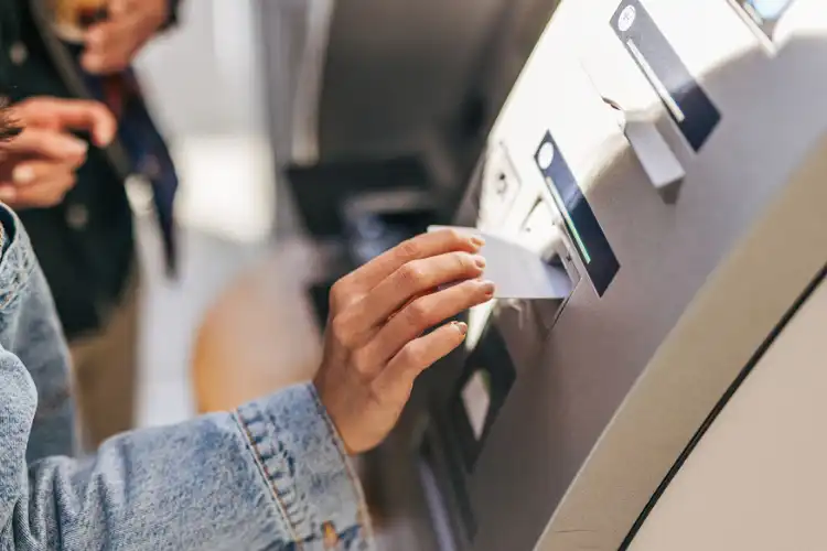 Pessoa sacando dinheiro com cartão de débito internacional