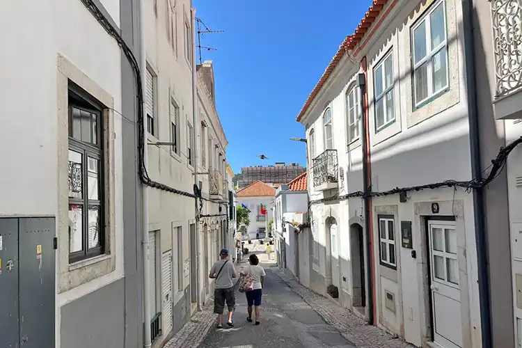 Casal caminha em rua estreita de Setúbal, Portugal