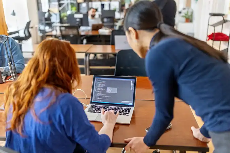 Duas programadoras trabalhando com tecnologia
