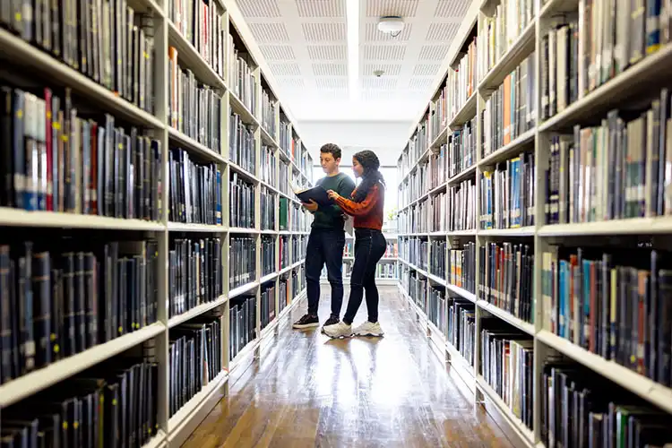 Estudantes procurando um livro na biblioteca