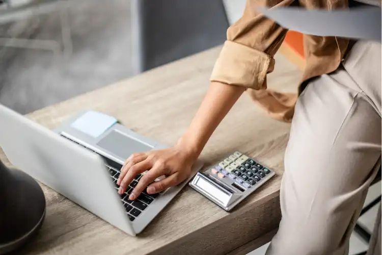 Pessoa consulta valores de conta em euro usando laptop