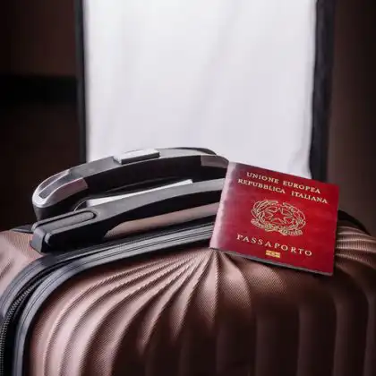 Passaporte italiano em cima de mala de viagem