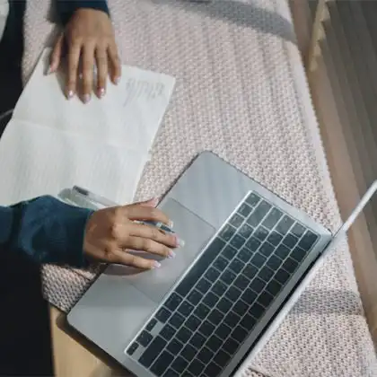 Pessoa digitando no computador, procurando sites para comprar passagens aéreas.
