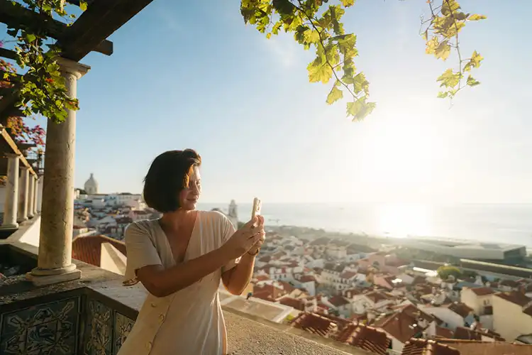 Mulher fotografa o horizonte em Lisboa