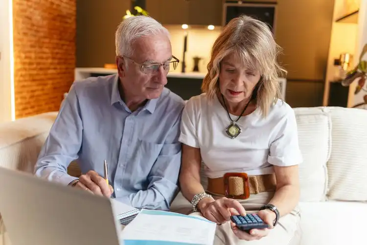 Casal de aposentados analisando finanças e calculando imposto de renda na Espanha