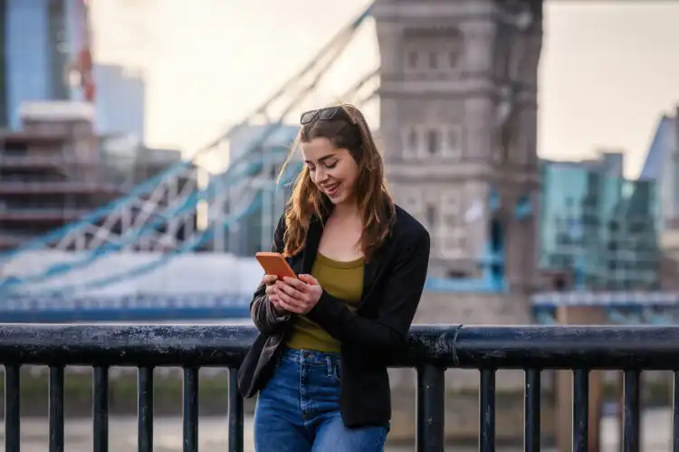 Mulher enviando mensagem com seu chip de celular na Inglaterra