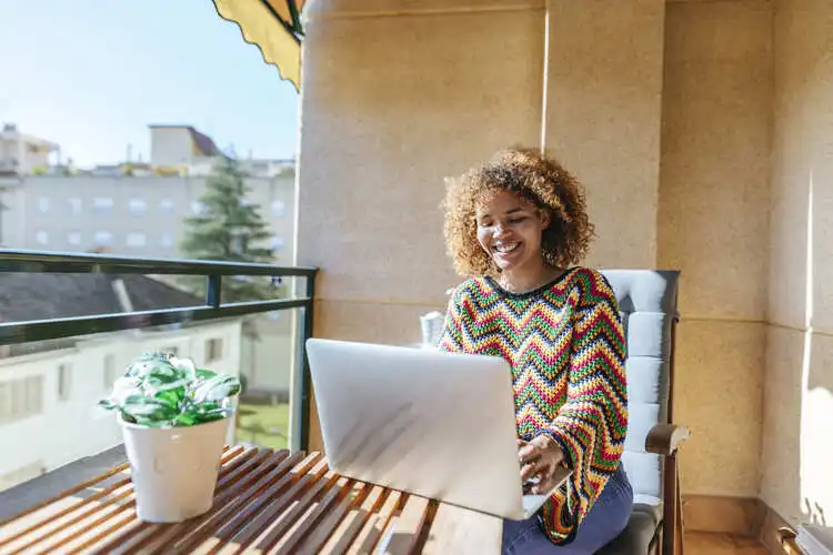 Brasileira usando notebook em casa na Espanha organizando a declaração do imposto de renda
