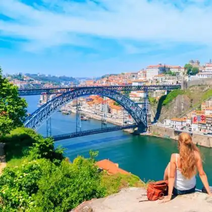 Mulher com seguro em viagem à Portugal, observa a cidade do Porto