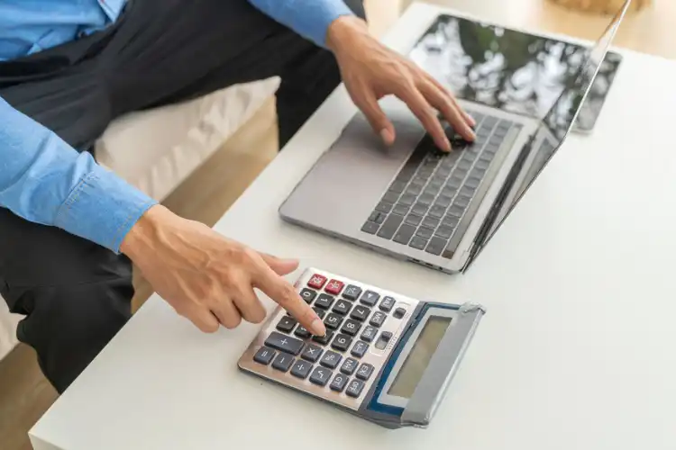 Homem calculando taxas da transferência internacional.