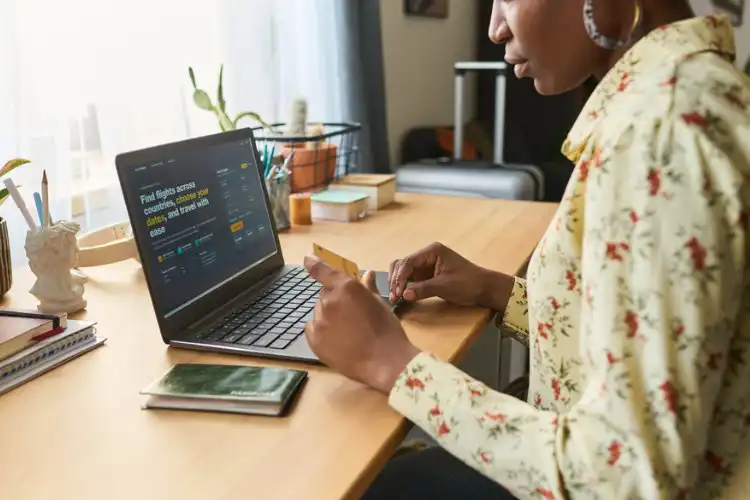 Mulher fazendo compra online com cartão internacional para Europa.